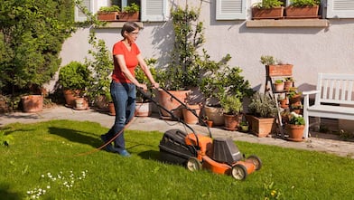 Woman mowing lawn in her front yard